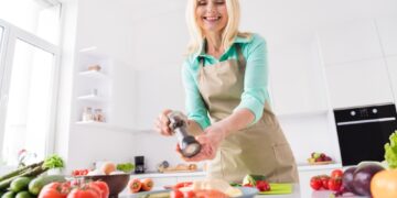 Ερευνητές από το Ηνωμένο Βασίλειο διερεύνησαν πρόσφατα κατά πόσο οι μεσήλικες και οι ηλικιωμένοι που καταναλώνουν περισσότερα τρόφιμα πλούσια σε θρεπτικά συστατικά εμφανίζουν υψηλότερα επίπεδα ευτυχίας, μεγαλύτερη ικανοποίηση από τη ζωή και καλύτερη συνολική ευεξία. Οι επιστήμονες βασίστηκαν στα δεδομένα της μελέτης English Longitudinal Study of Ageing (ELSA), στην οποία συμμετείχαν 3.103 ενήλικες ηλικίας άνω των 50 ετών. Η εκτίμηση της διατροφικής πρόσληψης έγινε μέσω αναφορών για δύο τυχαίες ημέρες, κατά τις οποίες καταγράφηκε η κατανάλωση φρούτων, λαχανικών, ψαριών και πολυακόρεστων λιπαρών οξέων (PUFAs). Πώς αξιολογήθηκε η ευεξία Η ευεξία μετρήθηκε σε τρεις βασικούς τομείς: Ευδαιμονική ευεξία: αίσθηση νοήματος, σκοπού στη ζωή και προσωπικής εξέλιξης. Ηδονική ευεξία: επίπεδα ευτυχίας και θετικών συναισθημάτων. Ικανοποίηση: συνολική αξιολόγηση της ζωής. Οι συμμετέχοντες συμπλήρωσαν σχετικά ερωτηματολόγια και στη συνέχεια δόθηκαν βαθμολογίες για κάθε επιμέρους τομέα. Τα πλεονεκτήματα της συγκεκριμένης μελέτης περιλάμβαναν το μεγάλο και αντιπροσωπευτικό δείγμα, καθώς και την εξέταση πολλαπλών διατροφικών παραγόντων σε σχέση με τις τρεις διαστάσεις της ευεξίας, με παράλληλη προσαρμογή για πιθανούς συγχυτικούς παράγοντες που θα μπορούσαν να επηρεάσουν τα αποτελέσματα. Ώρα για μεσημεριανό: Ποια θεωρείται η ιδανική για περισσότερη ενέργεια και καλύτερη διάθεση; ΔΙΑΒΑΣΕ ΕΠΙΣΗΣ Ώρα για μεσημεριανό: Ποια θεωρείται η ιδανική για περισσότερη ενέργεια και καλύτερη διάθεση; Από την άλλη πλευρά, η έρευνα παρουσίασε και ορισμένους περιορισμούς, καθώς βασίστηκε σε δεδομένα αυτοαναφοράς, τα οποία ενδέχεται να περιλαμβάνουν αποκλίσεις ή ανακρίβειες. Επιπλέον, χρησιμοποιήθηκε διατομικός σχεδιασμός, γεγονός που σημαίνει ότι τα δεδομένα αποτυπώνουν μια συγκεκριμένη χρονική στιγμή και δεν επιτρέπουν ασφαλή συμπεράσματα αιτιότητας. Ποιες τροφές συνδέονται με καλύτερη διάθεση μετά τα 50; Τα βασικά ευρήματα της μελέτης Σύμφωνα με τα αποτελέσματα, τα οποία δημοσιεύτηκαν στο British Journal of Health Psychology: Η κατανάλωση τουλάχιστον μίας μερίδας ψαριού την εβδομάδα συνδέθηκε σημαντικά με υψηλότερα επίπεδα ευτυχίας, ακόμη και μετά από προσαρμογή για παραμέτρους όπως η ψυχική υγεία και το εισόδημα. Η κατανάλωση φρούτων και λαχανικών αρχικά φάνηκε να σχετίζεται με αυξημένα επίπεδα ευεξίας, ωστόσο η συσχέτιση αυτή αποδίδεται κυρίως στη μείωση συμπτωμάτων κατάθλιψης σε άτομα με υψηλότερη πρόσληψη. Η επίτευξη της σύστασης για τουλάχιστον 5 μερίδες ημερησίως συνδέθηκε με τα υψηλότερα σκορ ευεξίας, παρότι οι περισσότεροι συμμετέχοντες κατανάλωναν κατά μέσο όρο περίπου 2 μερίδες. Η πρόσληψη πολυακόρεστων λιπαρών οξέων εμφάνισε πιο ασθενείς και λιγότερο σταθερές συσχετίσεις με την ευεξία. Οι ερευνητές εξηγούν ότι τα λιπαρά ψάρια πιθανόν ενισχύουν τη διάθεση μέσω της υποστήριξης των εγκεφαλικών μηχανισμών που ρυθμίζουν νευροδιαβιβαστές όπως η σεροτονίνη και η ντοπαμίνη. Αντίθετα, η κατανάλωση φρούτων και λαχανικών φαίνεται να βελτιώνει την ευεξία κυρίως μέσω της μείωσης των αρνητικών ψυχολογικών συμπτωμάτων. Διατροφή, υγεία και ευεξία: μια σύνθετη σχέση Η μελέτη ανέδειξε ότι παράγοντες όπως η σωματική υγεία, η οικονομική κατάσταση και η ψυχολογική διάθεση επηρεάζουν τόσο τις διατροφικές επιλογές όσο και την ευεξία. Για παράδειγμα, η καλύτερη οικονομική κατάσταση μπορεί να διευκολύνει την πρόσβαση σε ποιοτικά τρόφιμα, ενώ η καλή ψυχική υγεία μπορεί να αυξήσει την ευχαρίστηση που αντλεί κανείς από τη διατροφή. Συνολικά, τα ευρήματα υπογραμμίζουν ότι η διατροφή αποτελεί έναν τροποποιήσιμο παράγοντα που μπορεί να συμβάλει στη βελτίωση της ευεξίας σε μεγαλύτερες ηλικίες. Η αύξηση της κατανάλωσης φρούτων, λαχανικών και ψαριών φαίνεται να αποτελεί μια απλή και οικονομικά αποδοτική στρατηγική για καλύτερη διάθεση και ποιότητα ζωής, αν και απαιτούνται περαιτέρω μακροχρόνιες μελέτες για την πλήρη επιβεβαίωση των αποτελεσμάτων.